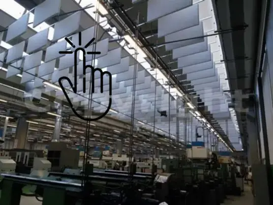 Vista di baffles acustici sospesi installati in un capannone industriale: intervento professionale per ridurre il riverbero e migliorare l’acustica negli ambienti produttivi ad alta rumorosità.
