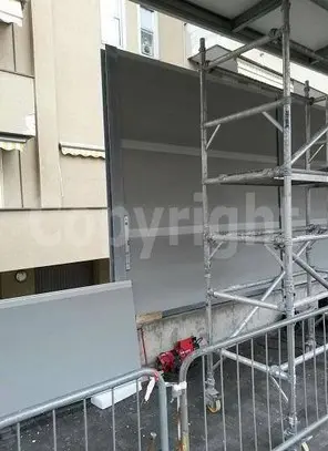 Montaggio pannelli fonoisolanti per contenere rumori urbani su facciata edificio<br /><br />