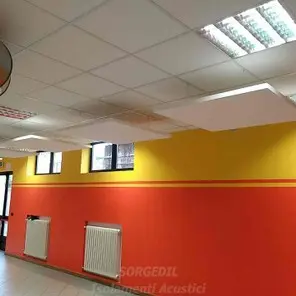 Baffles fonoassorbenti bianchi tra luci in ambiente scolastico<br /><br />